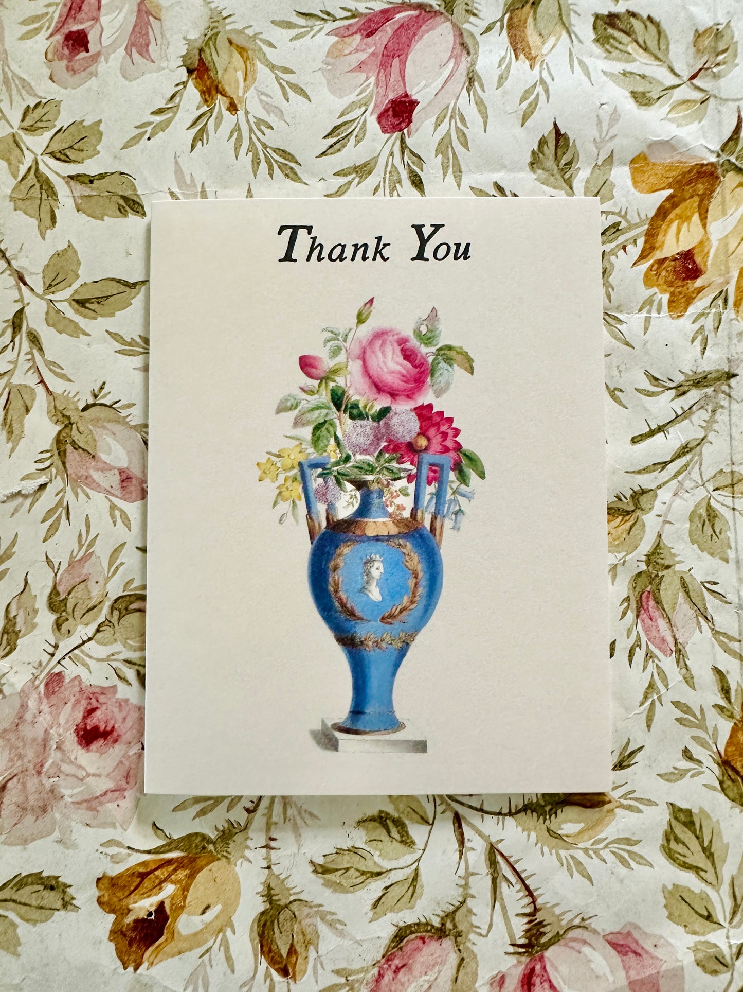 Thank You card with rose bouquet illustration displayed on antique pink and gold floral wallpaper, by Caldwell's Miscellaneous Fancy Goods.