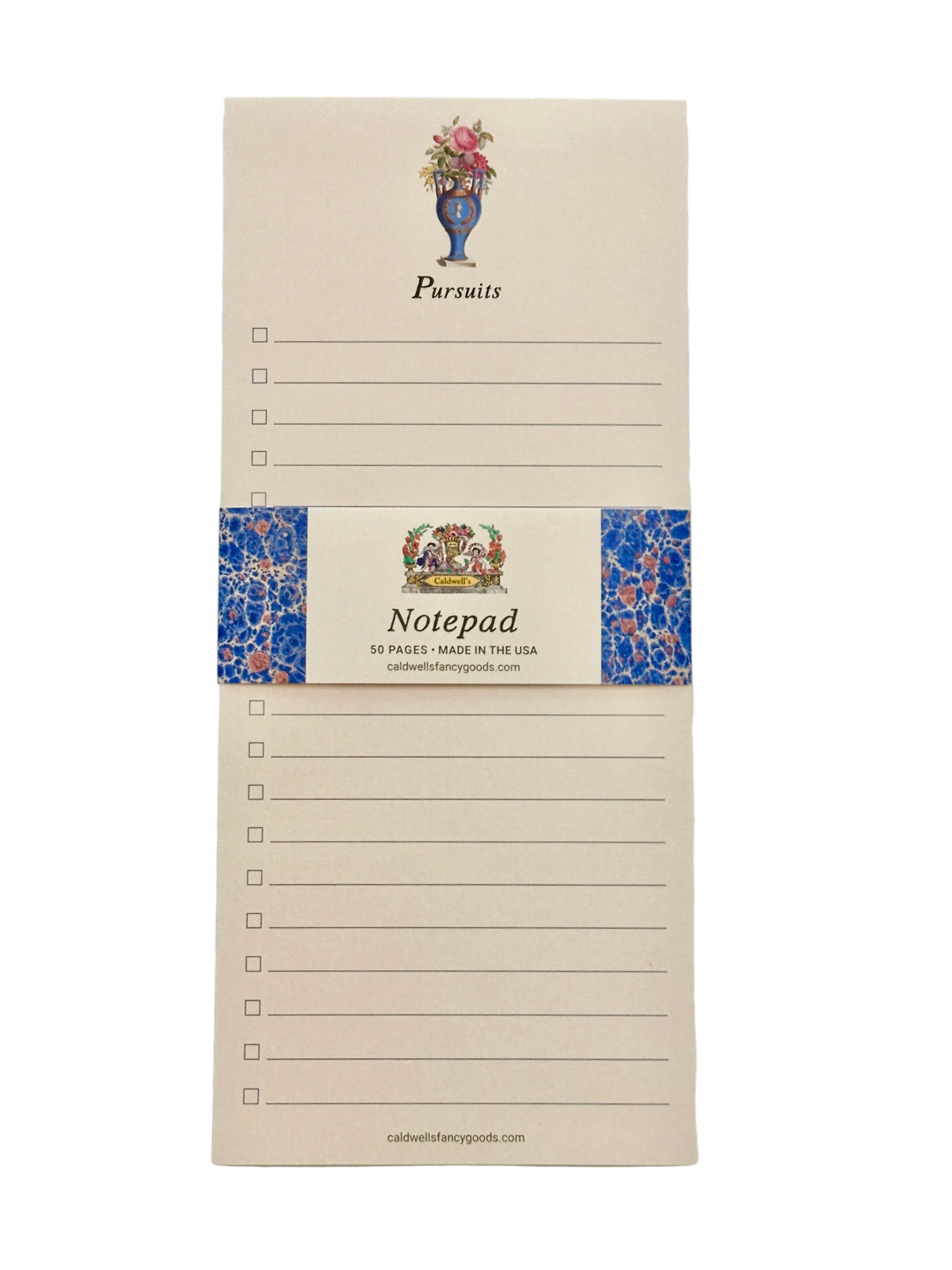 A cream-colored notepad with a blue floral patterned band around the center, featuring the word 'Pursuits' at the top and 'Notepad' on the band, photographed against a light neutral background.